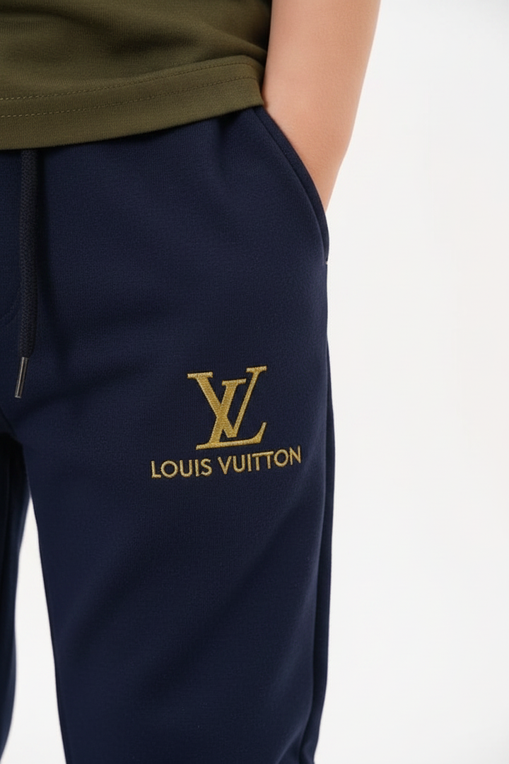 Détail monogramme doré style LV sur la jambe du jogging bleu marine enfant