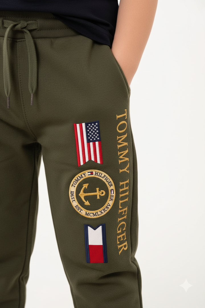 Détail broderie ancre dorée Tommy Hilfiger sur la jambe du jogging vert kaki enfant