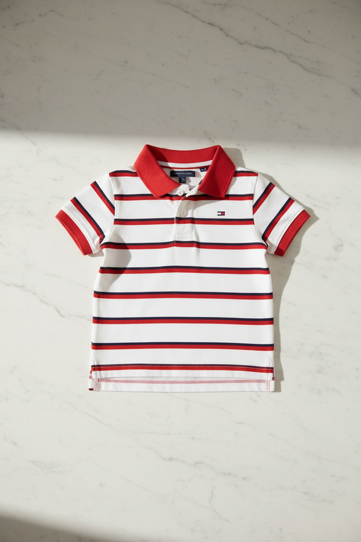 Polo Tommy Hilfiger blanc et rouge étalé sur table moderne