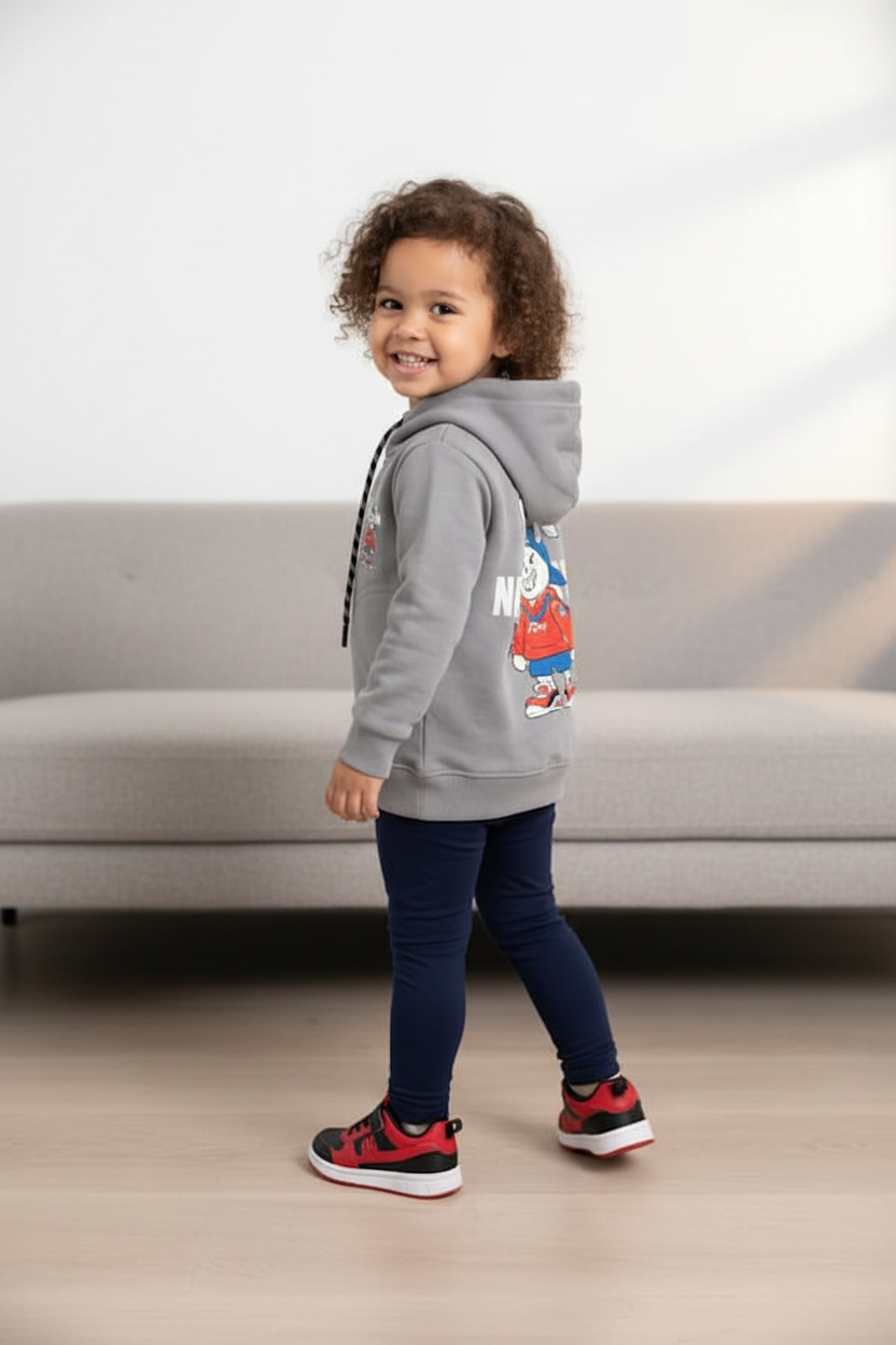 Petit garçon afro portant le hoodie gris unisexe CHAYA STYLE, pose de dos, intérieur moderne chic