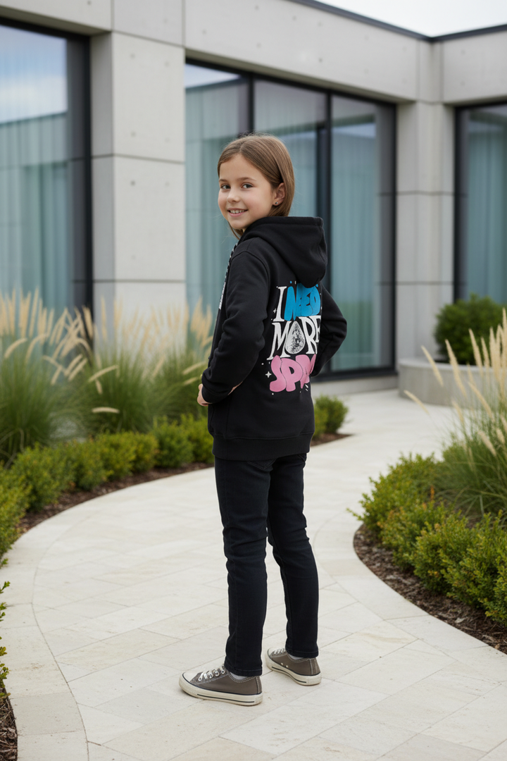 Enfant portant le hoodie noir CHAYA STYLE, pose debout, extérieur moderne chic