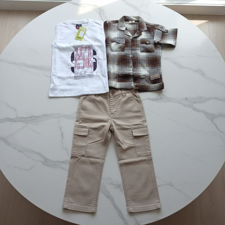 Ensemble 3 pièces garçon - chemise à carreaux, pantalon cargo droit beige et t-shirt blanc - flat lay sur table